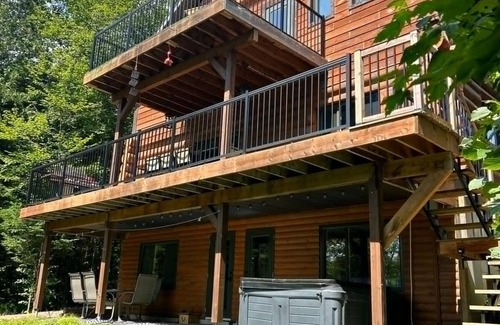 Mauricie Cabina | Chalet en bois rond au bord de l'eau avec spa, foyer et table de pool.