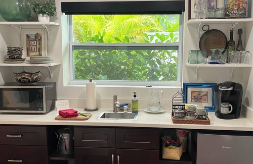 Parrot Cove Cabaña | Chill on the patio overlooking the pool & lush gardens with privacy!
