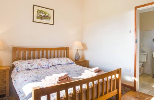 Talybont Chalet De Esquí | Enlli Lodge tiene capacidad para 2 personas más mascotas con jacuzzi y vistas al mar y la montaña y está rodeada de tierras de cultivo