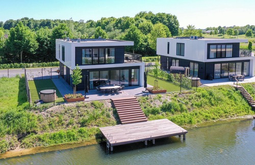Biddinghuizen Casa | Luxury 10-person villa on the water with hot tub, private jetty, spacious terrace and 4 bedrooms. Located at Villa Resort Harderwold, near Harderwijk and the Veluwemeer!