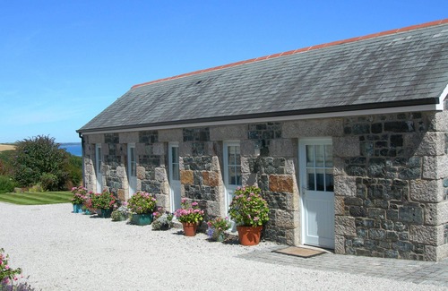 Helford Passage Cabaña | Pond Cottage - cabaña de lujo con vistas al mar sobre un valle arbolado