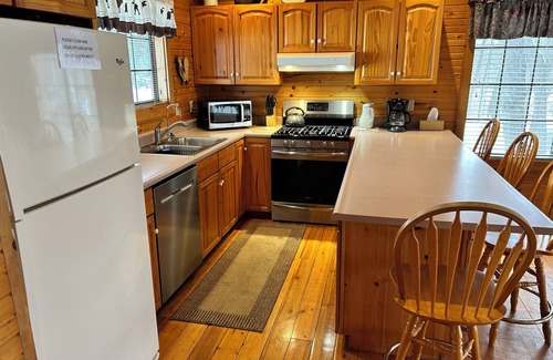 South Haven Cabaña | Riverbend Retreat Middle Branch Cottage Fireplace and hot tub with river view.