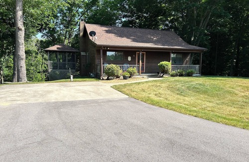 South Haven Cabaña | Riverbend Retreat Middle Branch Cottage Fireplace and hot tub with river view.