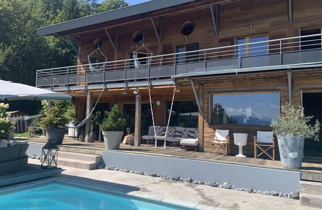 Villa contemporánea de madera, vista abierta al lago de Annecy y sus montañas.