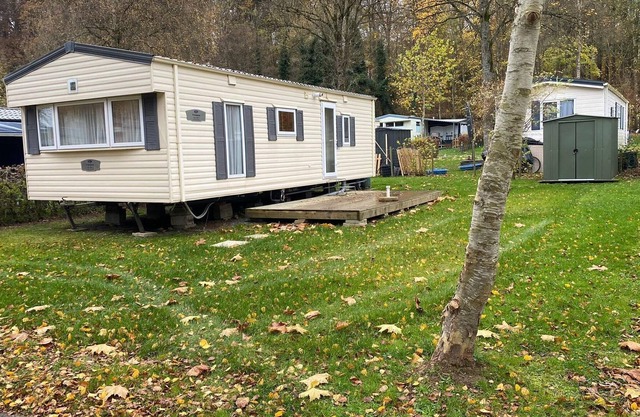 Caravana residencial situada en medio de un camping en un paraje muy natural.