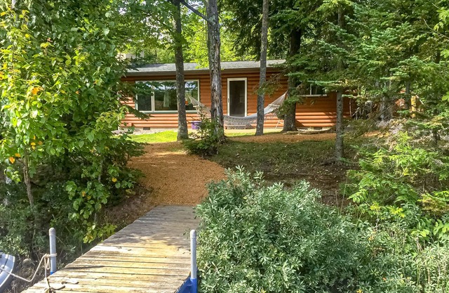 Cabaña frente al lago que admite perros con chimenea de leña, patio y hoguera: kayaks y canoa.