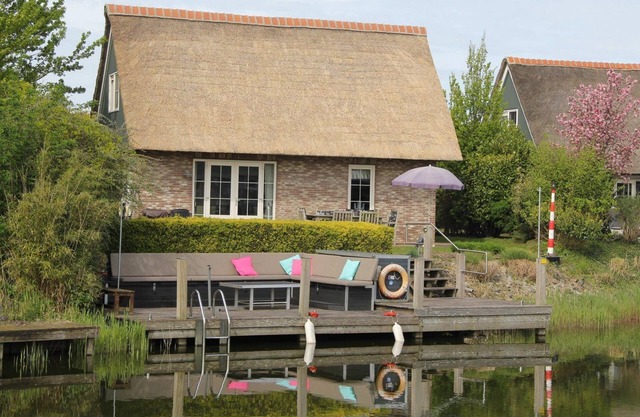 Detached luxury villa with a terrace and jetty next to open waters