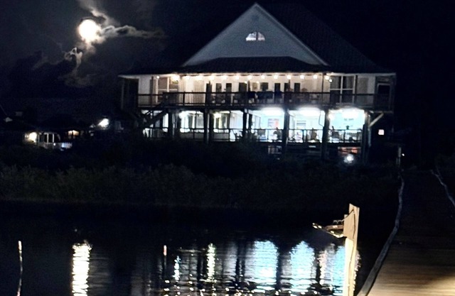 Hermosa Casa Frente Grande en la bahía con muelle de pesca iluminado.