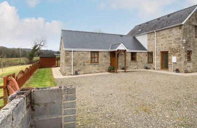 Casa de vacaciones de piedra de Gales construida con el río Ceri que pasa por el corral en la parte inferior de la