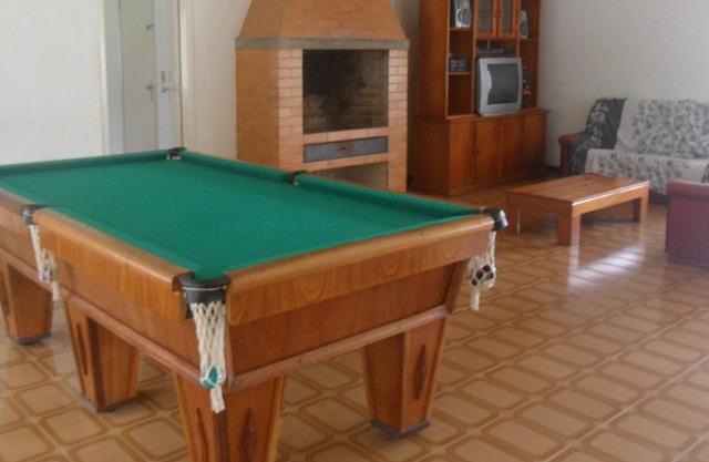 Sitio con gran piscina, barbacoa, sala de juegos y césped verde.