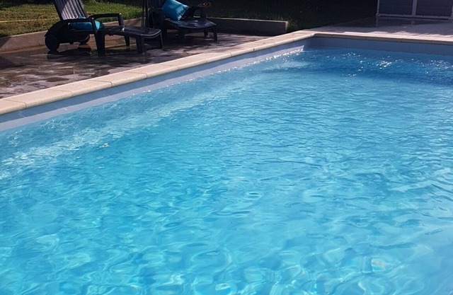 Estudio en villa con jardín y piscina.
