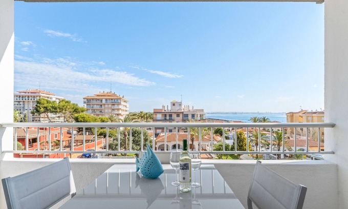 Punta Prima Apartamento | Apartamento 'Beach Front Sea View Punta Prima' con vistas al mar, Wi-Fi y aire acondicionado.