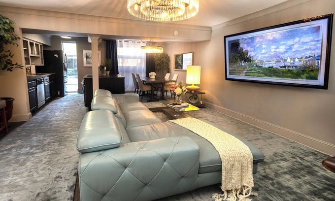 Lower Greenville Condominio | Upscale 2BR Dallas condo with pool view and access to an award-winning courtyard featuring a resort-style pool, hot tub, dry sauna, and lush lounge areas. Enjoy a 77″ smart TV, sleek leather sofa, and modern kitchen for a stylish, comfortable stay.