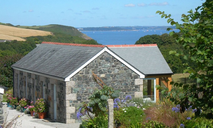 Helford Passage Cabaña | Pond Cottage - cabaña de lujo con vistas al mar sobre un valle arbolado