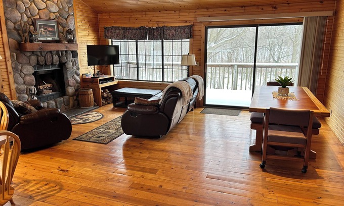 South Haven Cabaña | Riverbend Retreat Middle Branch Cottage Fireplace and hot tub with river view.